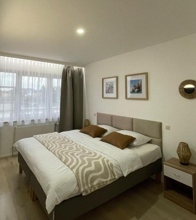 a bedroom with a large bed with two pillows at Rooms Brussels Airport- 'The Good Place' in Zaventem