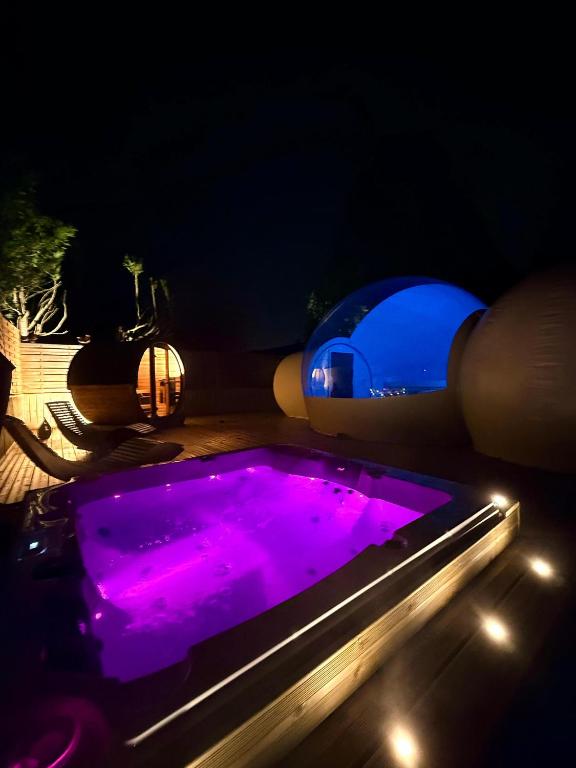 a swimming pool at night with purple lights at Bubblesuite47 in Précy-sur-Oise