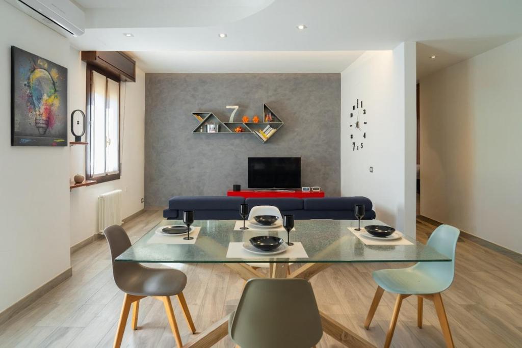 a dining room with a glass table and chairs at Emilia Suite Space in Modena