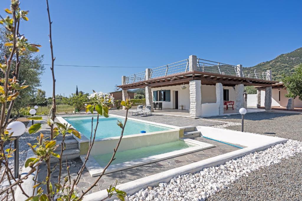 a villa with a swimming pool and a house at Domu Fama in Tertenìa