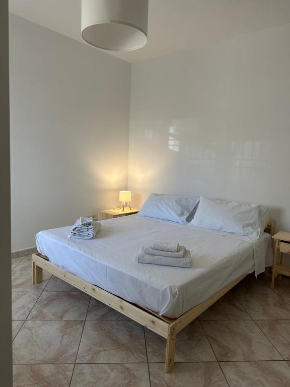 a bed with white sheets and towels on it at La Casa di Aira in Martina Franca