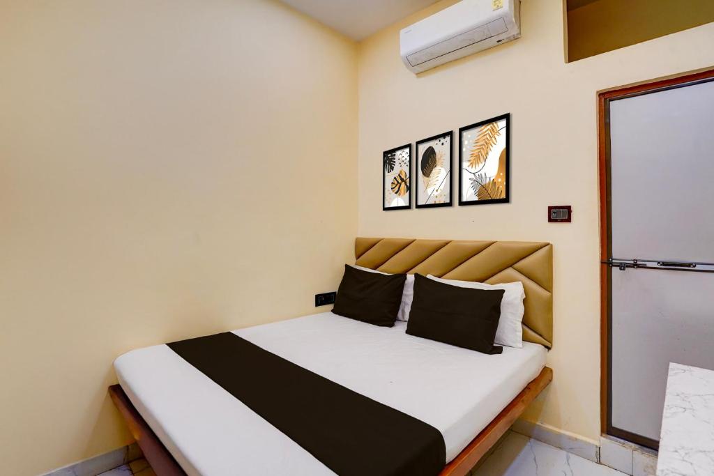 a small bedroom with a bed with white and black at Hotel O Utsav In in Jabalpur