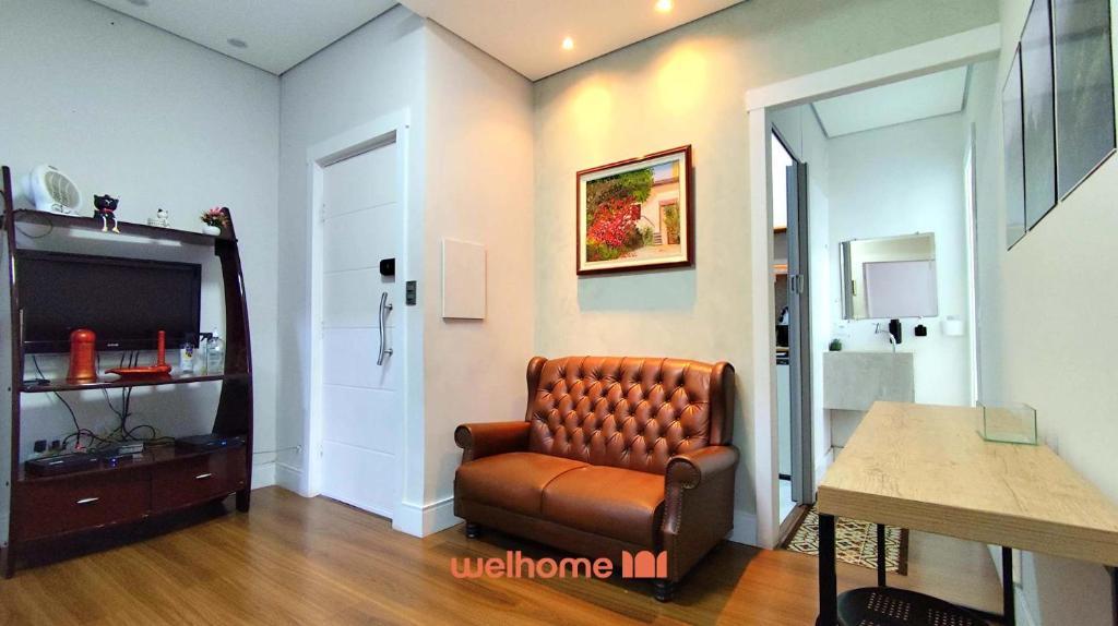 a living room with a leather chair and a television at Apartamento em Campinas a 300m do Centro in Campinas