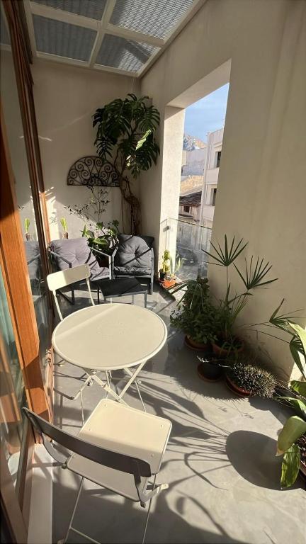 a patio with a table and chairs and plants at La Casa di Mariano in Terrasini