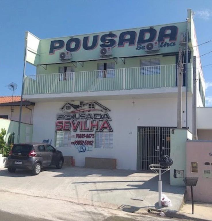 a building with a car parked in front of it at Pousada Sevilha in Sumaré