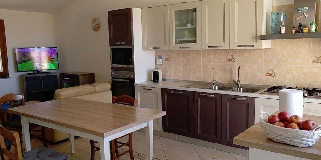 a kitchen with a table with a bowl of fruit on it at Domo Mea in Orgosolo