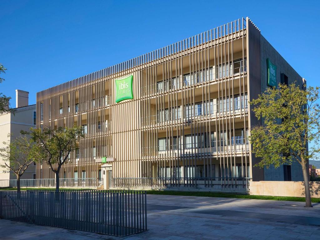 an office building with a fence in front of it at ibis Styles Montelimar Centre in Montélimar