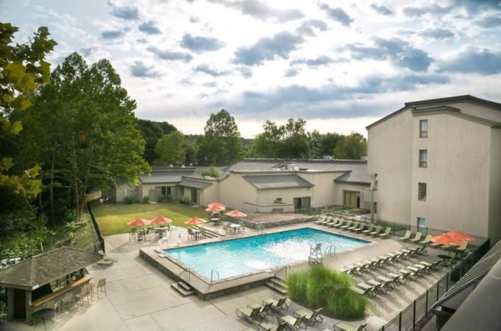 Draufsicht auf einen Pool mit Stühlen und einem Gebäude in der Unterkunft Heritage Hotel, Golf & Conference Center in Southbury