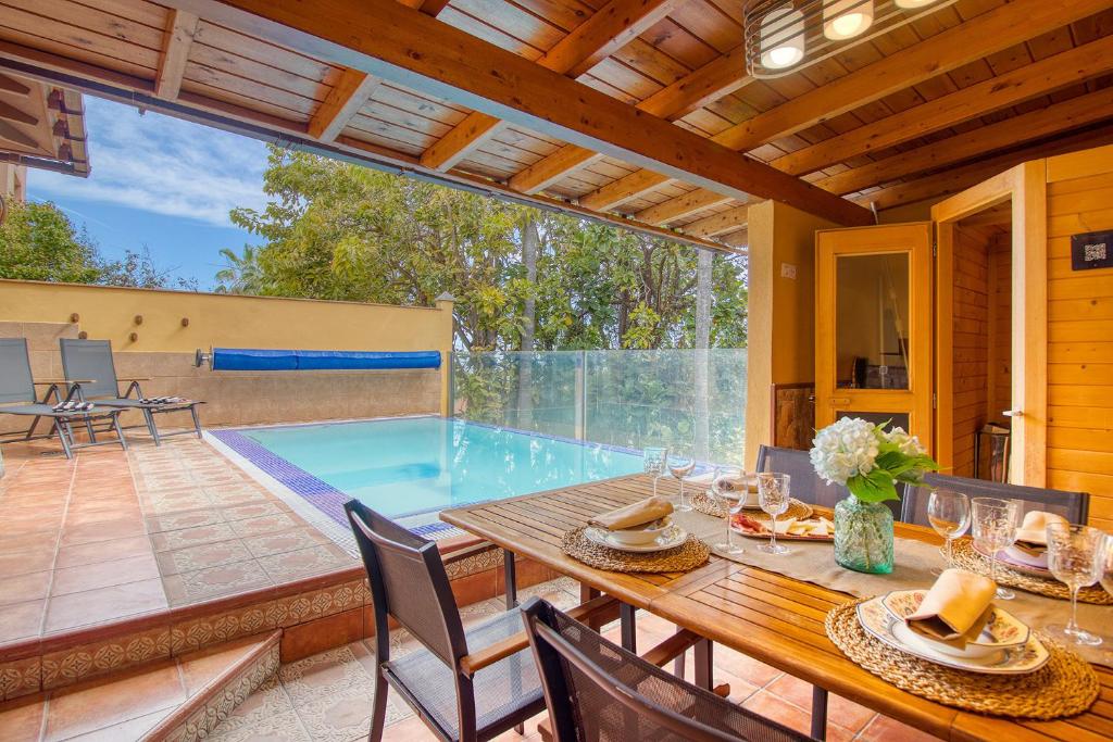 a dining room with a table and a swimming pool at 4BR Wellness Villa- Pool, Sauna, Gym in Puerto de la Cruz