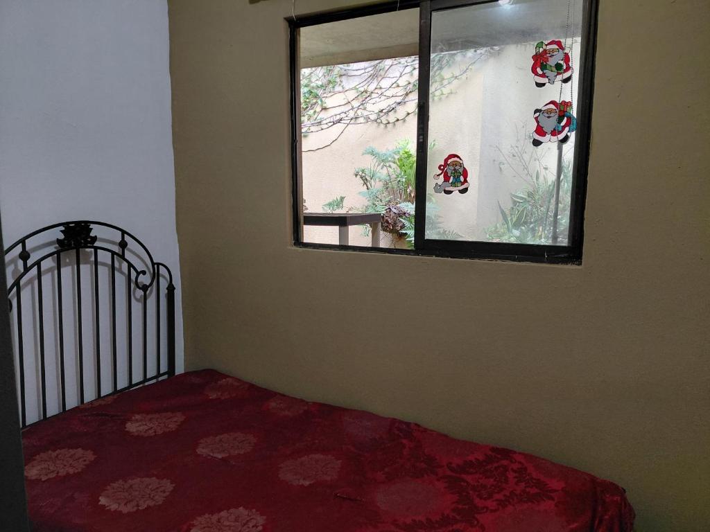 a bedroom with a window and a bed with a red carpet at San Remo 1 in San Pedro