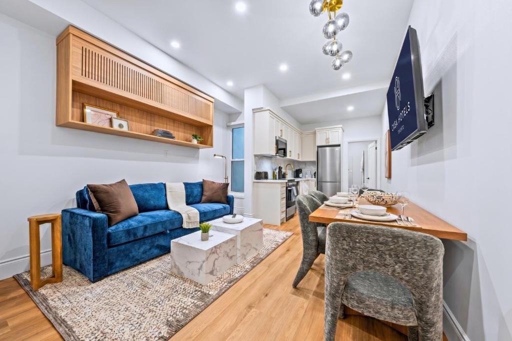 a living room with a blue couch and a table at Casa Hotels Gerrard Newly Built Suite Steps to Transit in Toronto