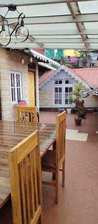 a wooden table and chairs on a patio at Nizel Inn in Darjeeling
