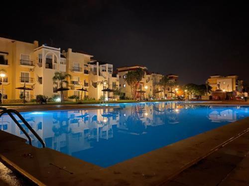 a large swimming pool at night with buildings at Saidia Marina in Saïdia