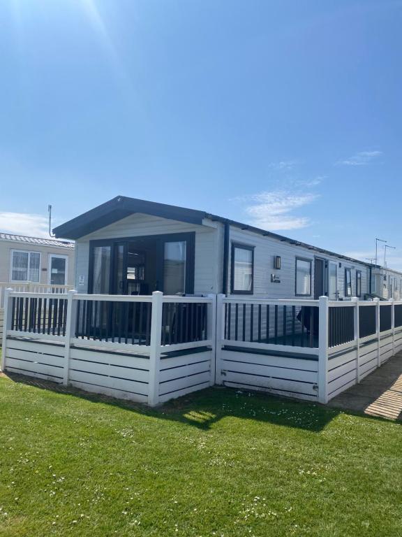 a white fence in front of a mobile home at Aqua bay whistable in Swalecliffe