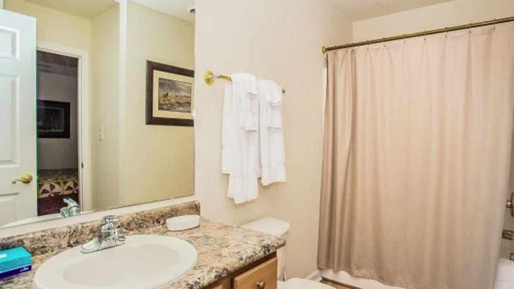 a bathroom with a sink and a shower curtain at WP651 Smokin' Views Penthouse in Pigeon Forge