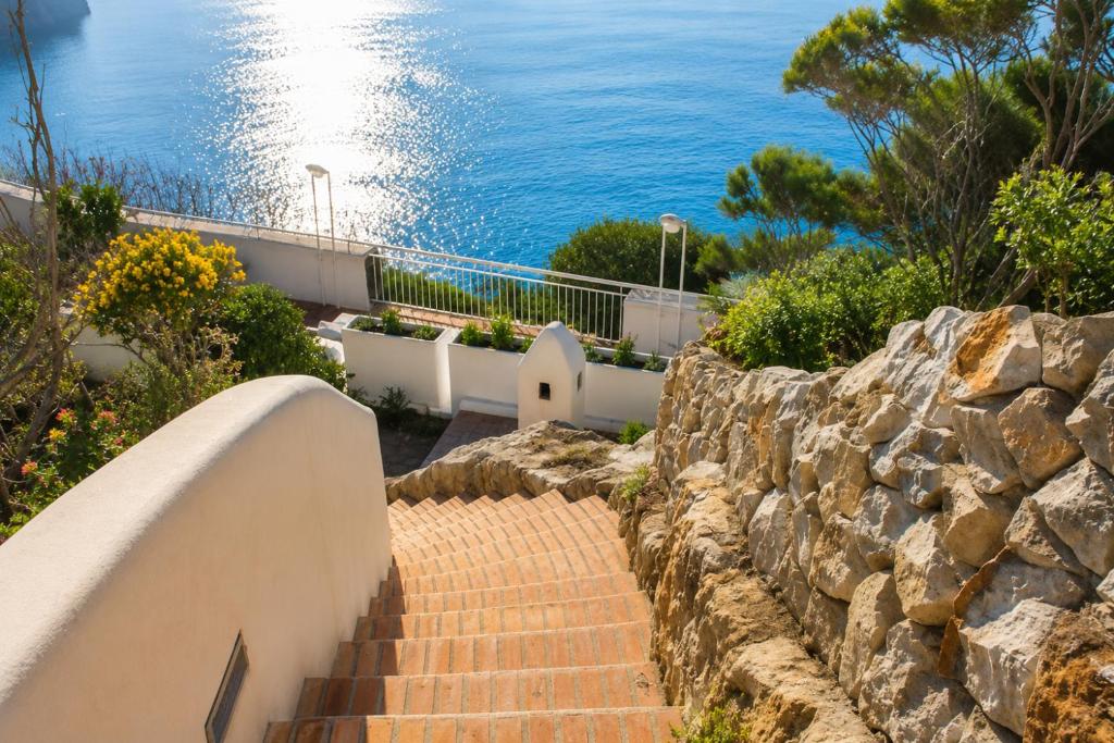 a set of stairs next to a stone wall at Maridea - Il Paradiso sulla Baia in Ponza