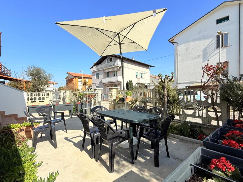 a patio with a table and chairs and an umbrella at SE238 - Marotta, quadrilocale con corte privata in Marotta