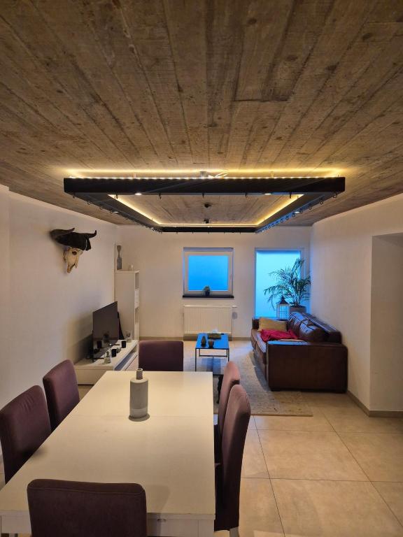a living room with a table and a couch at Chambres d'hotes in Bertrix