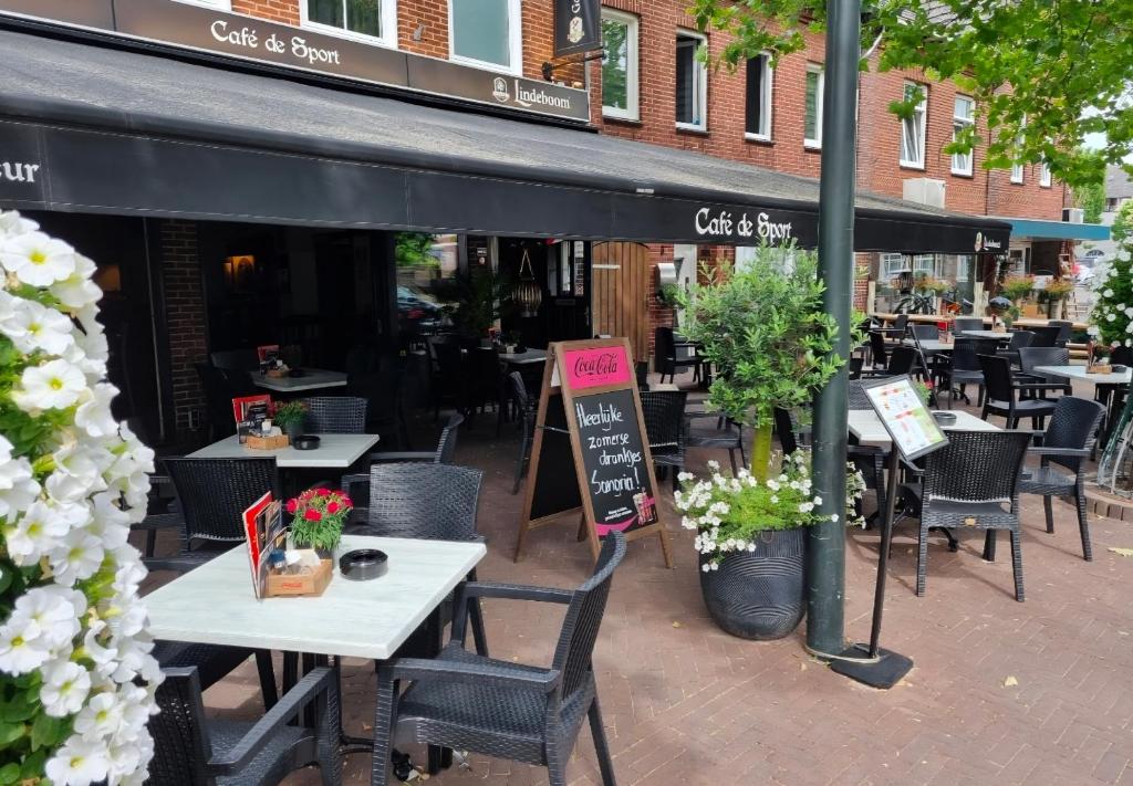 a restaurant with tables and chairs in front of a building at Hotel Café de Sport in Velden