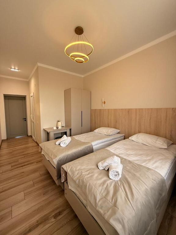 a bedroom with two beds with towels on them at Alcha Hotel Karakol in Karakol