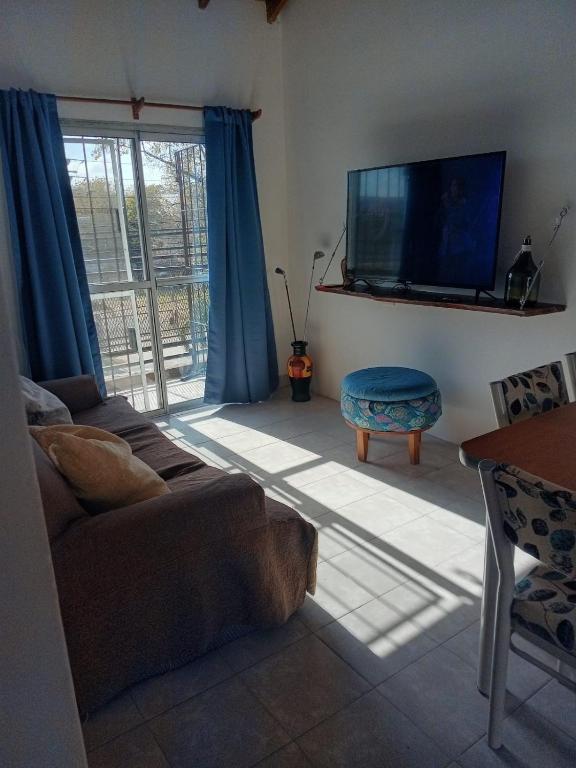 a living room with a couch and a flat screen tv at El Galpon Aparts in General Pacheco
