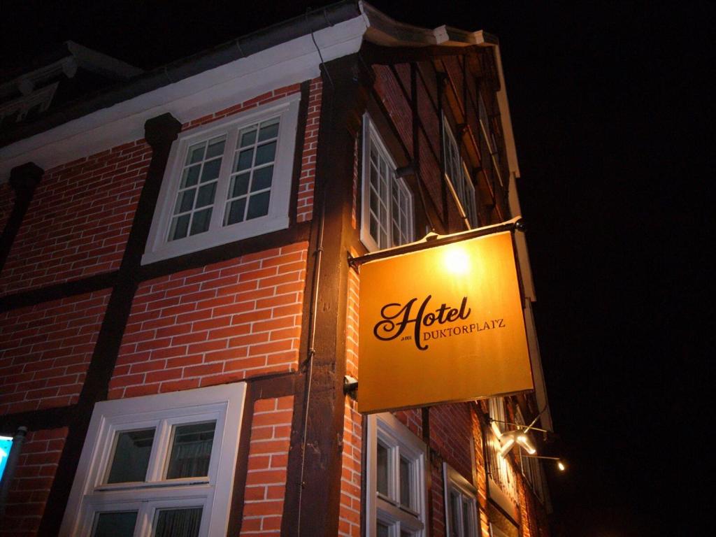a lit sign on the side of a brick building at Hotel am Doktorplatz in Rheda-Wiedenbrück