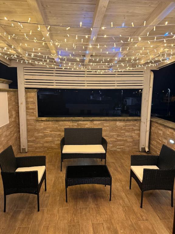a room with chairs and a table and lights on the ceiling at Illumina House 3 in Giurdignano