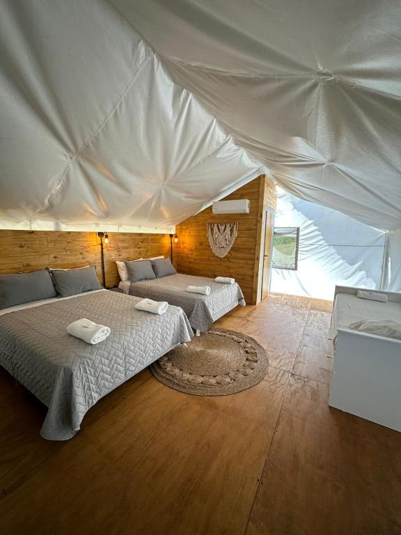 a bedroom with two beds in a tent at moraycamp in San Andrés de Giles