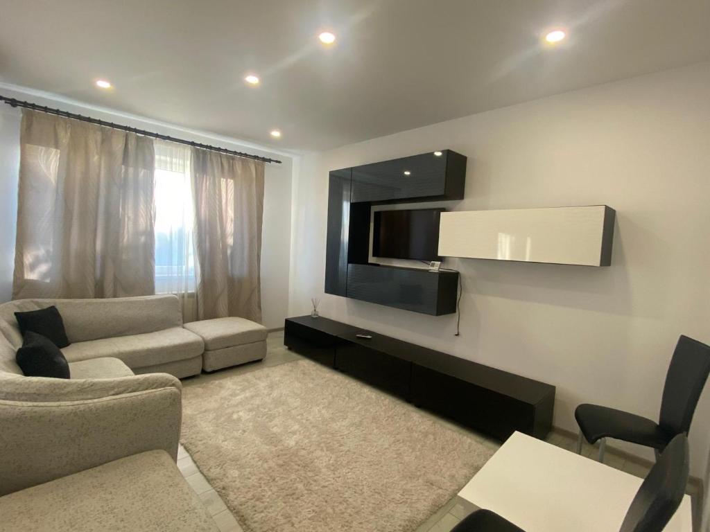 a living room with a couch and a flat screen tv at Apartament Kiri in Mangalia