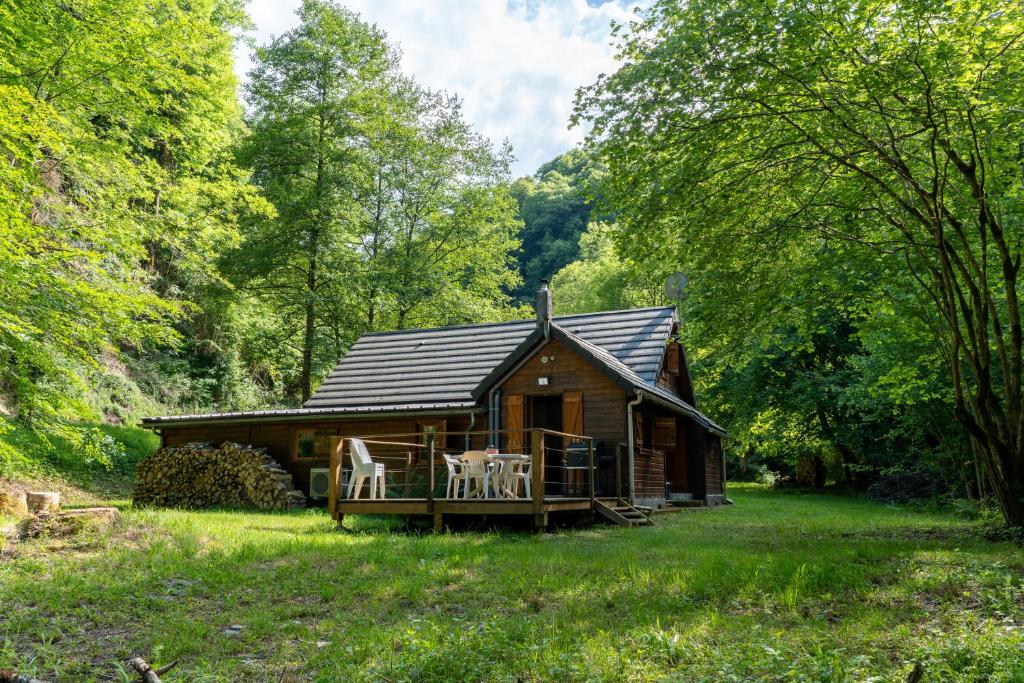 a cabin in the woods with a porch and a deck at Chalet du Lacus in Boutx