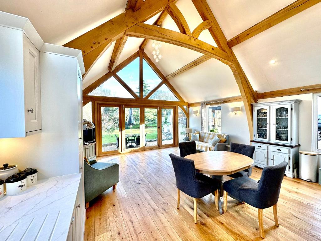 a kitchen and dining room with a wooden table and chairs at Holly Barn in Worcester