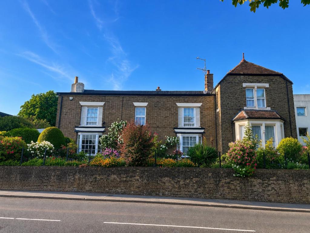 a brick house with a retaining wall and a street at The Beaumont in Sittingbourne