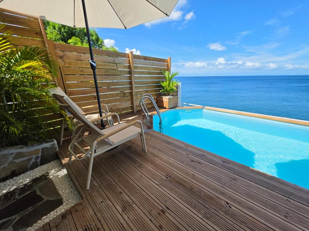 a chair and an umbrella next to a swimming pool at CLEMARA EVASION in Schœlcher