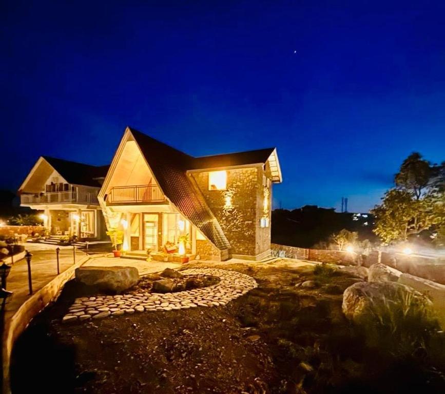 a home at night with a rock garden at Frogs Aviator's Cottage in Dharmsāla