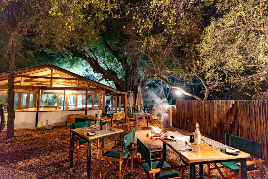 a restaurant with tables and chairs and a fire at Ndzhaka Tented Camp in Manyeleti Game Reserve