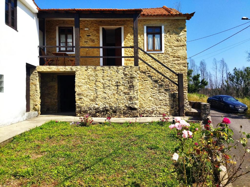 a stone house with a car parked in front of it at Quinta da Preciosa in Nebrijo