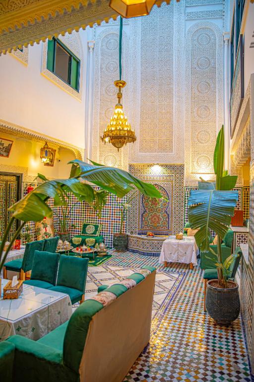 a living room with a couch and chairs and a chandelier at Riad YAMNA - Quiet Desire in Fez