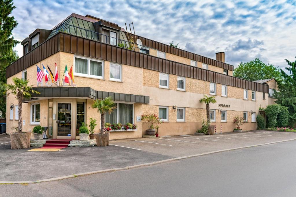 un edificio con dos banderas encima en Hotel Villa Sulmana, en Neckarsulm