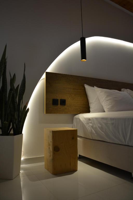 a bedroom with a bed and a potted plant at 44 suites Lygia in Paralia Vrachou