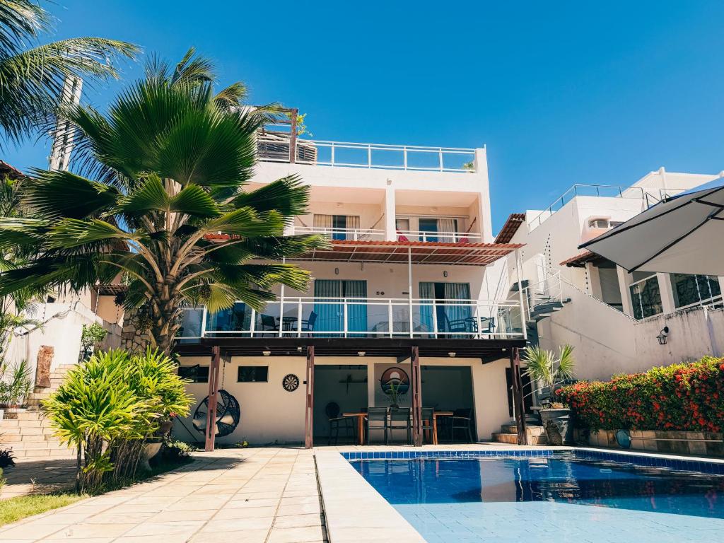 a house with a swimming pool and a palm tree at Residence Dunas in Natal