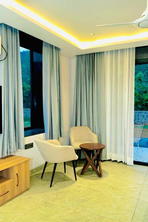 a living room with a chair and a table at Kaya Nature Resort in Ajabgarh
