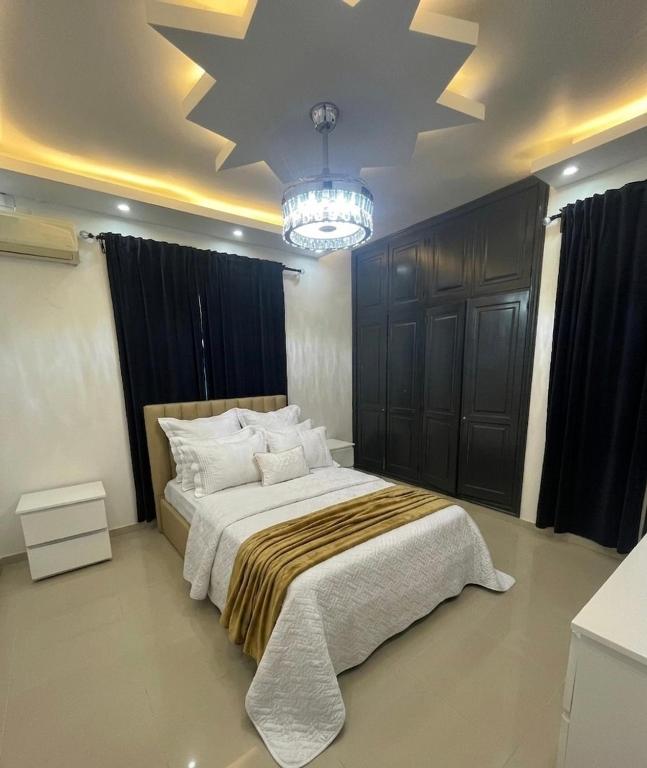 a bedroom with a large bed and a chandelier at Gladi Hidalgo in San Francisco de Macorís