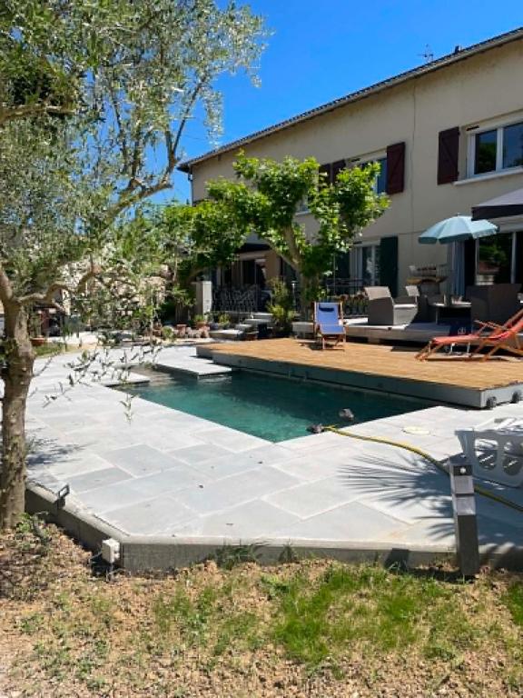 a swimming pool in front of a house at Chez-Sixtine Chambres d'Hôtes in Albon