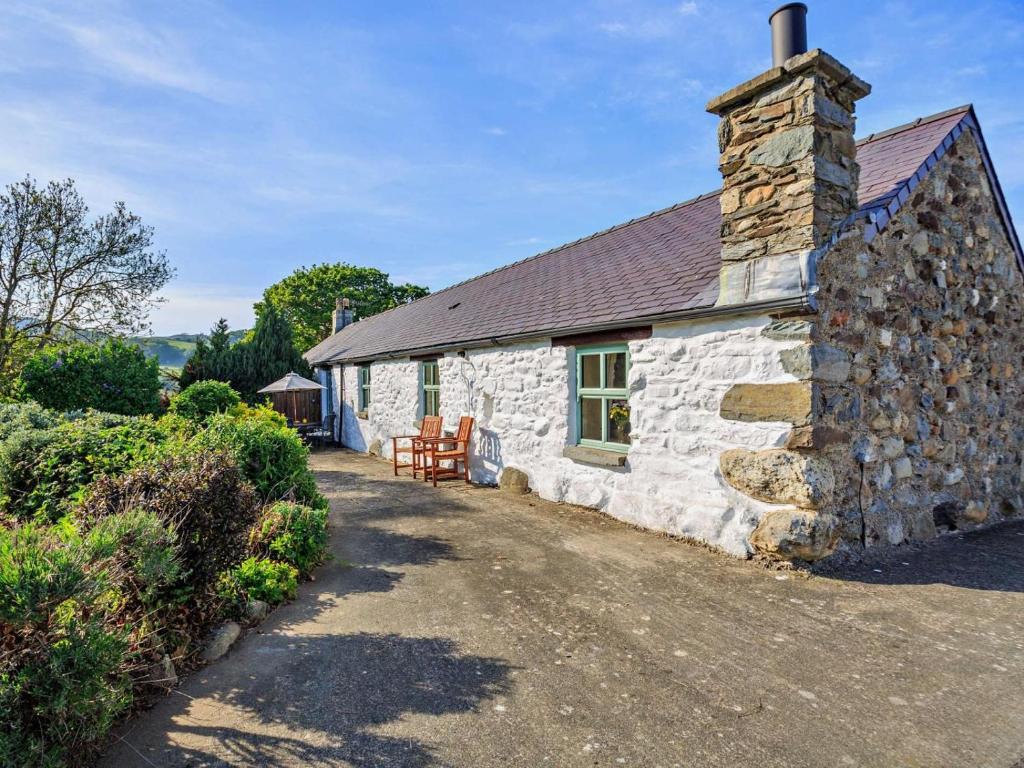 a stone cottage with a stone chimney and a patio at 2 Bed in Conwy oc-95905 in Conwy