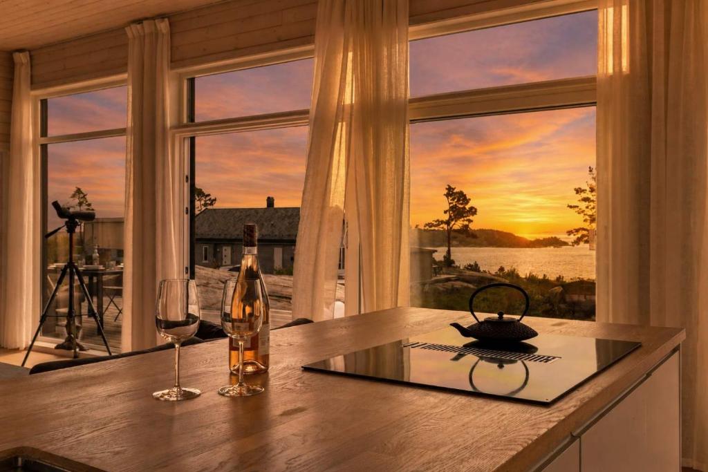 a kitchen with a table with wine glasses and a window at Seaside Escape - 10 Min to Ocean in Ytre Søndeled
