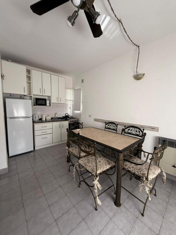 a kitchen with a table and chairs and a refrigerator at Ayres de Pinamar in Pinamar