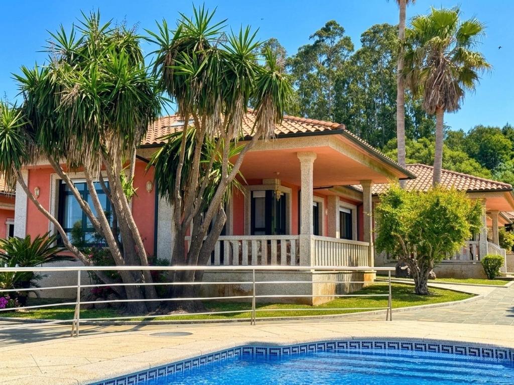 a house with a swimming pool in front of it at La Pepa Sanxenxo in Sanxenxo