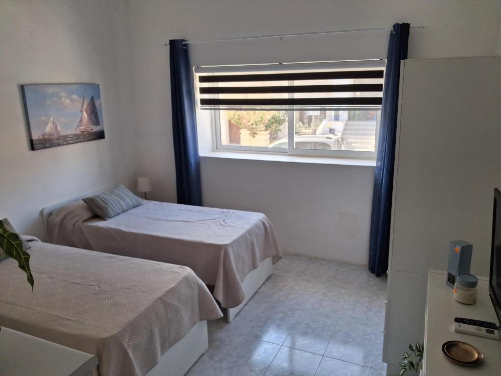 ein Schlafzimmer mit zwei Betten und einem Fenster in der Unterkunft 56, Windchimes in Pembroke