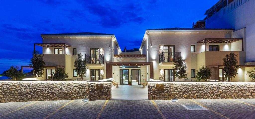 a large white house with a stone wall at Parga Gem P in Parga