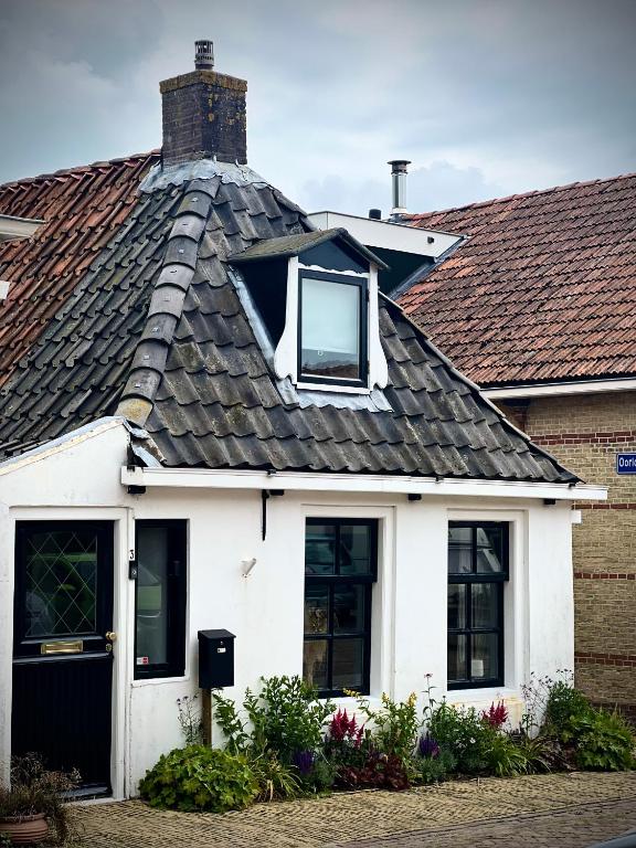 a white house with a gambrel roof at LITTLENEIGHBOUR in Pingjum
